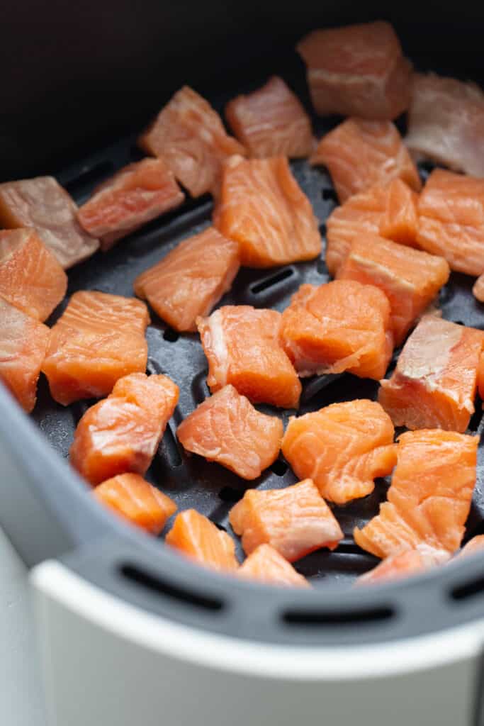 Salmon filets cubed in an air fryer.