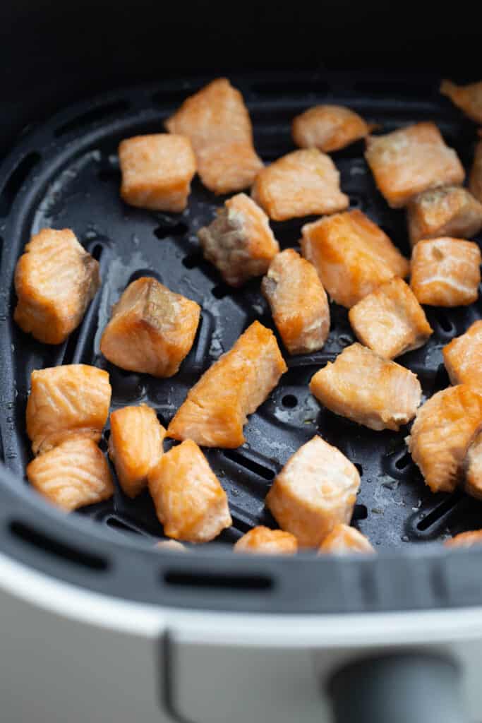 Cubes of salmon chunks in an air fryer.