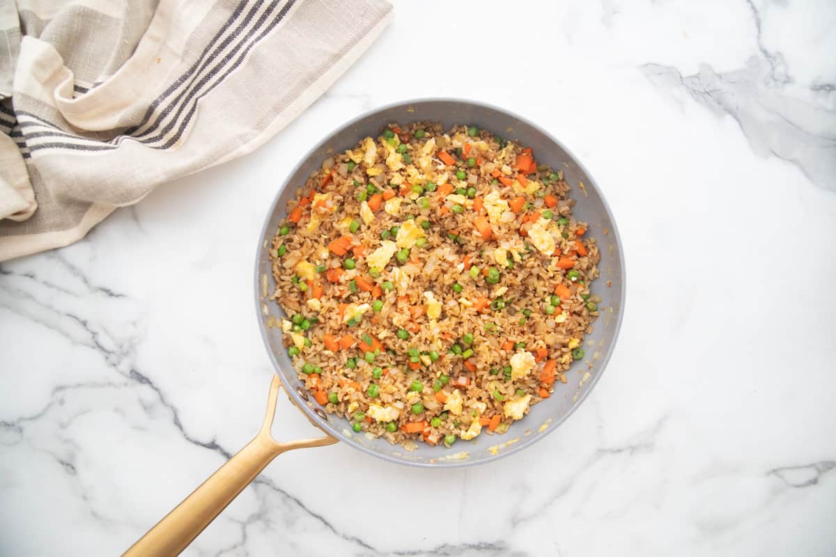 A non stick skillet with healthy hibachi fried rice made with brown rice and fresh vegetables.