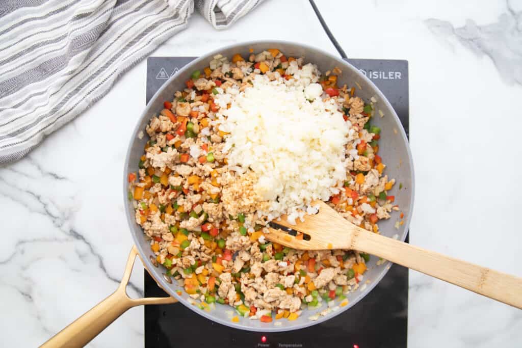 Skillet with ground chicken, peppers, and cauliflower rice.