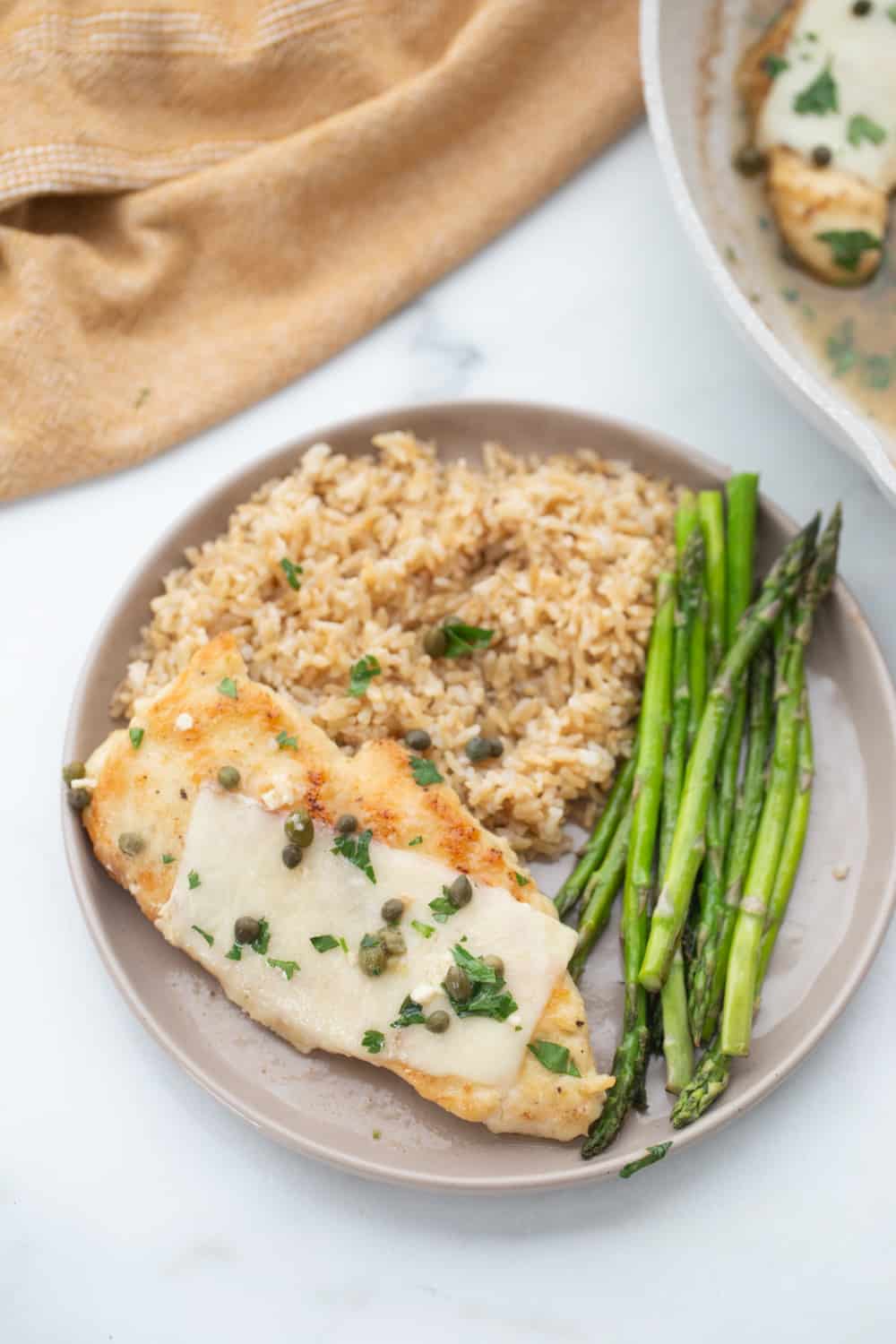 Chicken Scallopini served with roasted asparagus and brown rice.