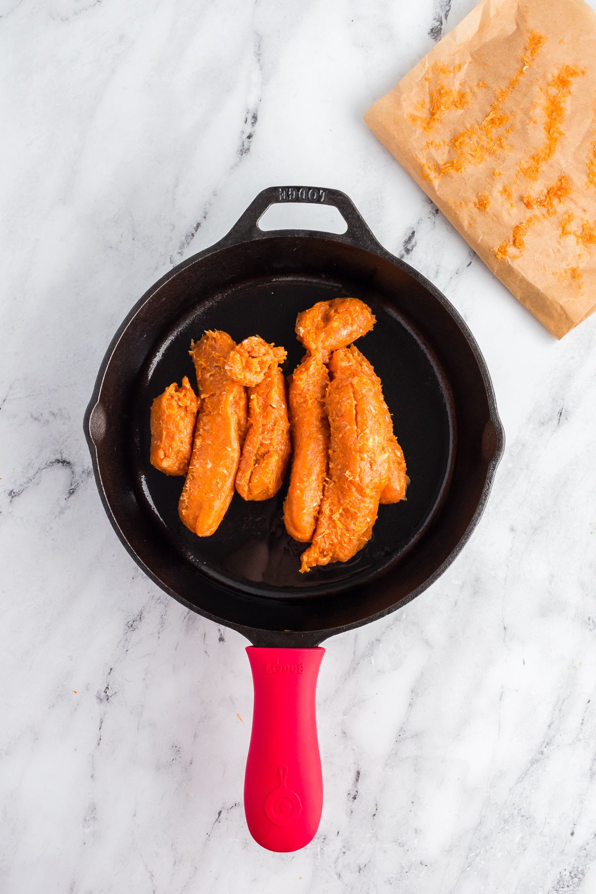 Skillet with Italian chicken sausage for zucchini lasagna.