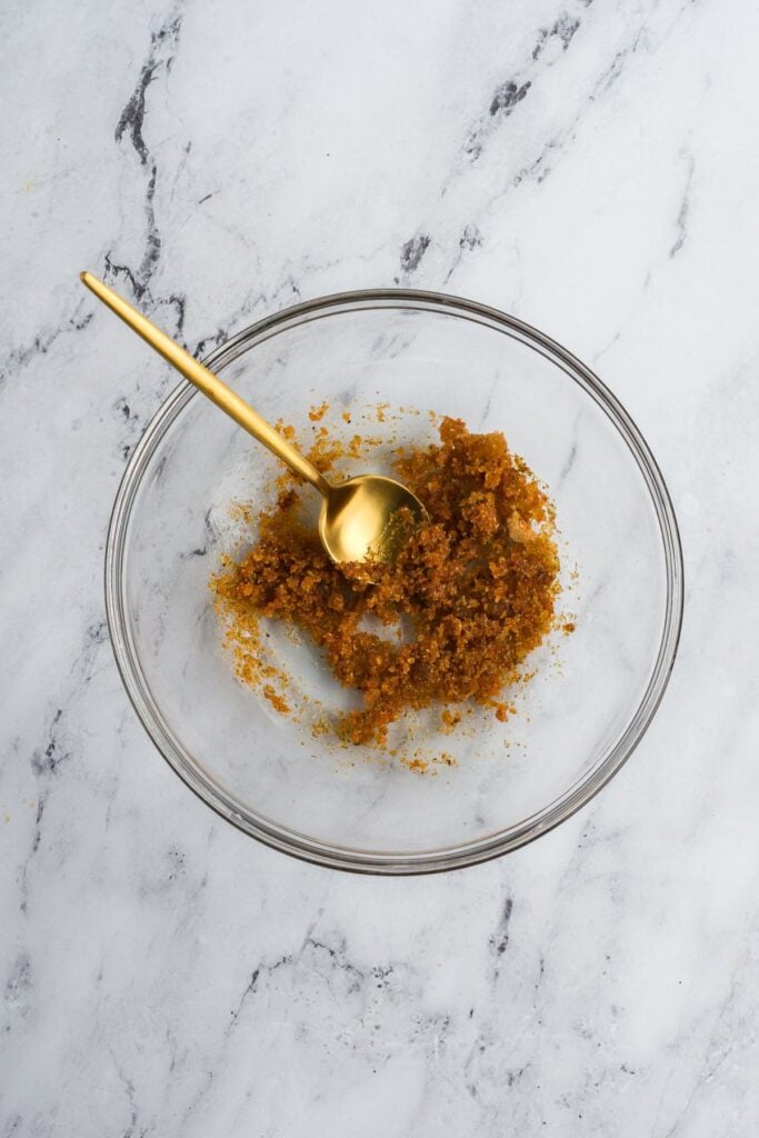 A clear bowl with spices mixed with olive oil for a turkey rub.