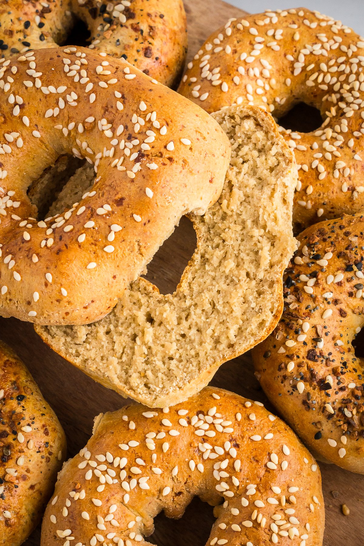 a pile of sliced gluten-free bagels shot from overhead with sesame seeds and everything bagel seasoning on top