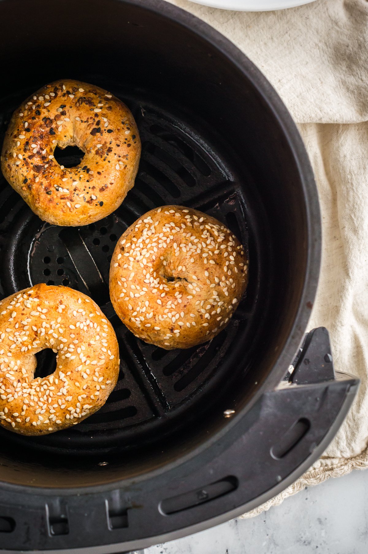 cooked high-protein bagels in an air fryer basket shot from overhead