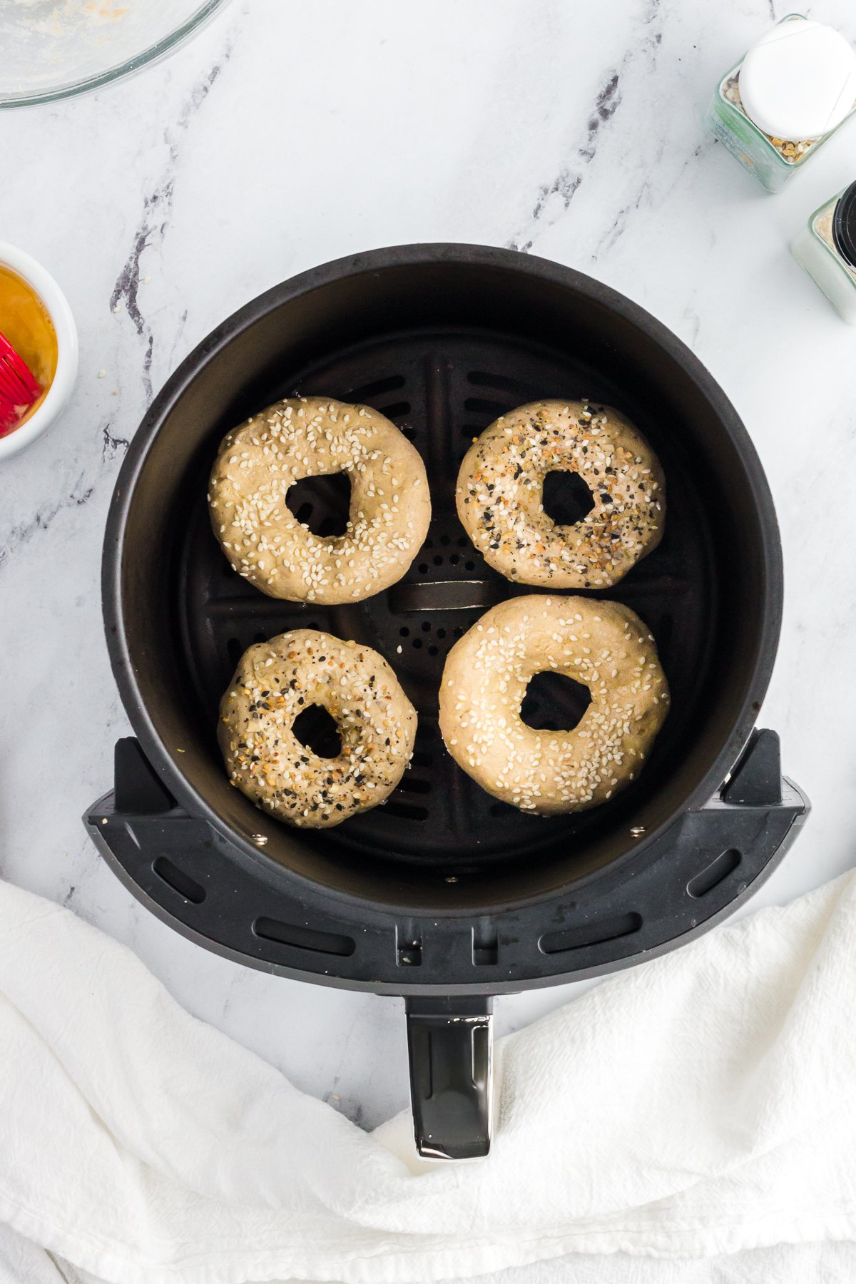 high-protein bagels in an air fryer basket before being cooked