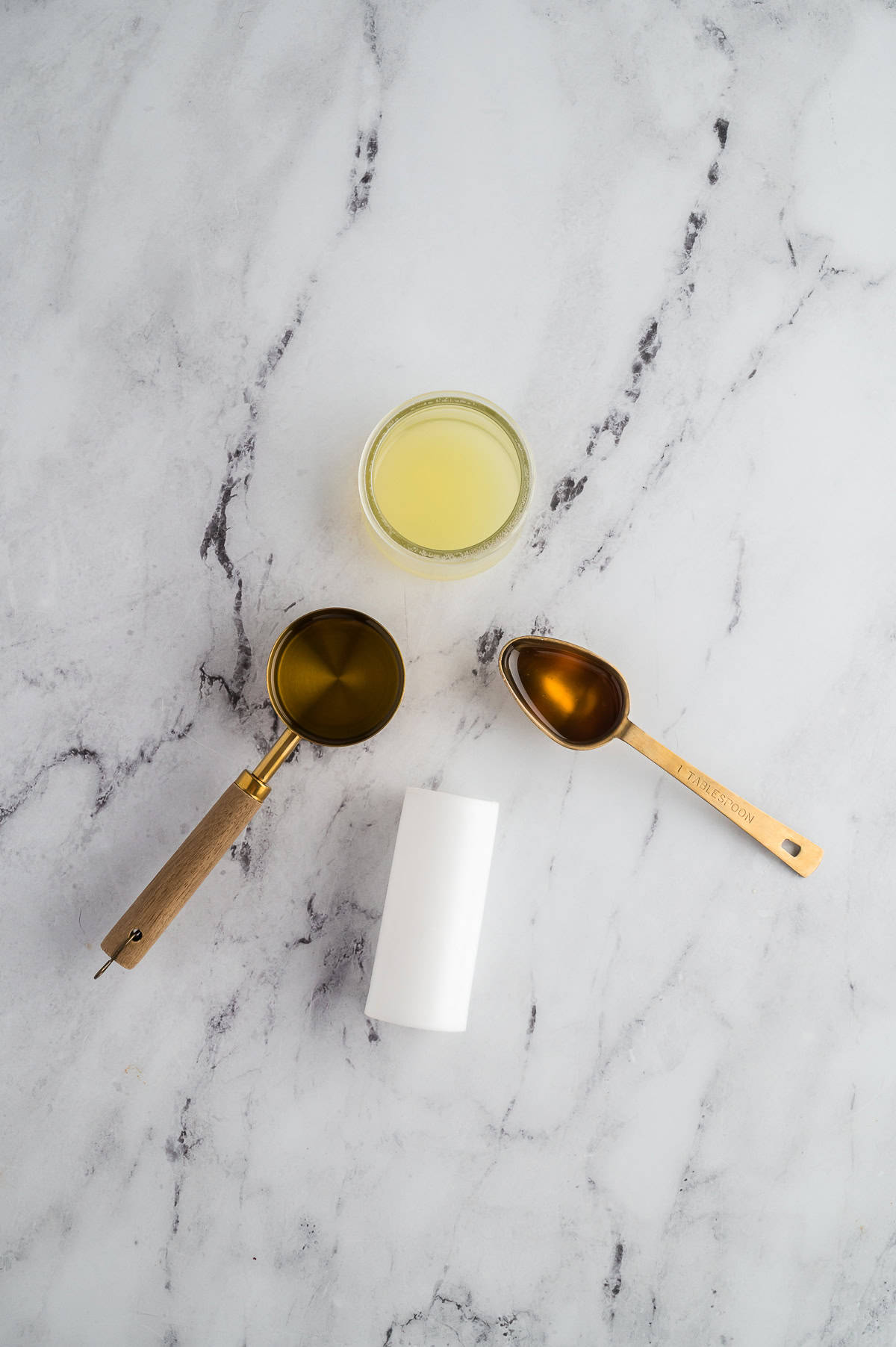 Lemon juice, olive oil, and honey measured out for a light dressing.