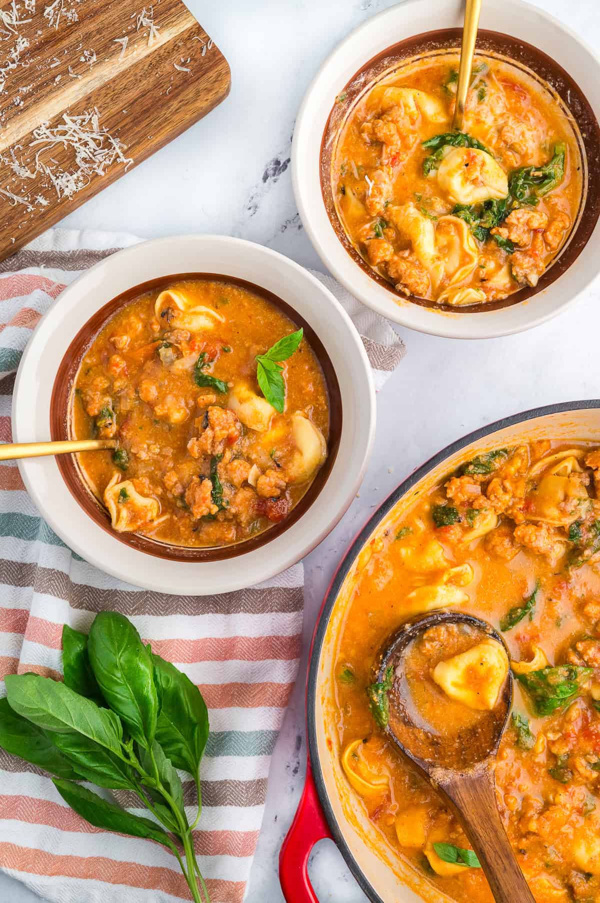 Three bowls of an Italian style tortellini soup that uses cauliflower to make it creamy.